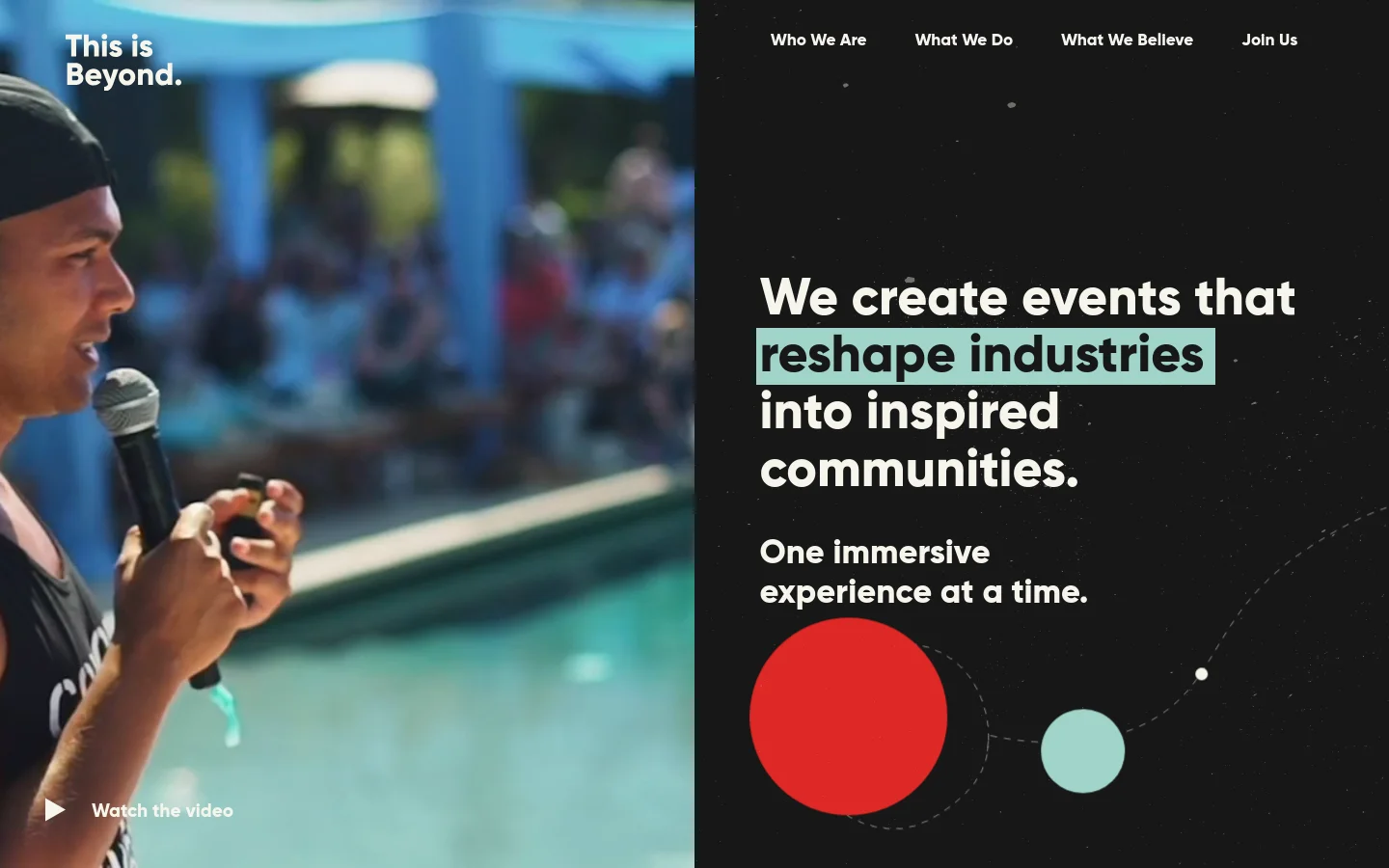 The desktop homepage features a split-screen hero section with a large photograph of a man speaking into a microphone on the left and a dark, textured right side containing the headline 'We create events that reshape industries into inspired communities' in bold white text. A navigation menu is at the top right, and a 'Watch the video' call to action is visible over the image and text. The color palette is dark with accents of teal and red circular graphics.