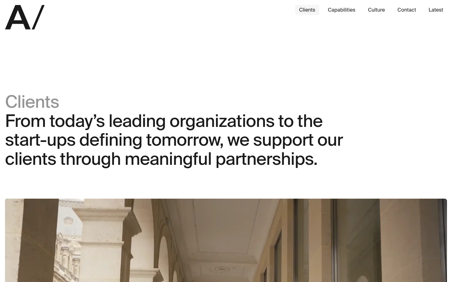 The desktop page features a minimalist white background with a large 'Clients' headline and a descriptive sub-headline. A navigation menu is at the top right, and a large, high-quality architectural hero image is positioned below the text.