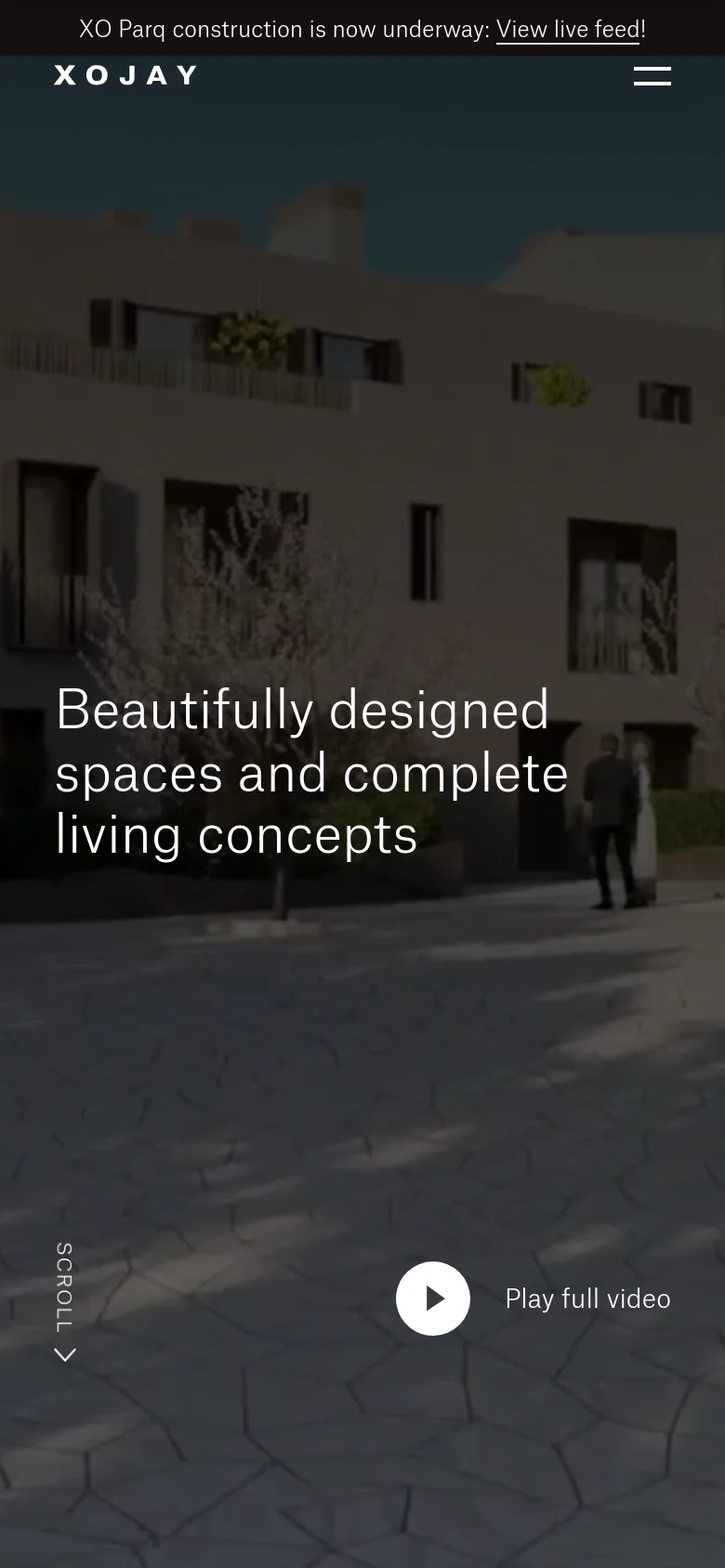 The mobile version presents a vertically oriented view of the same cinematic background, focusing on the building facade and courtyard. The headline is centered, and the navigation is condensed into a hamburger menu in the top right. The 'Play full video' button and 'Scroll' indicator are repositioned to fit the narrow screen layout.