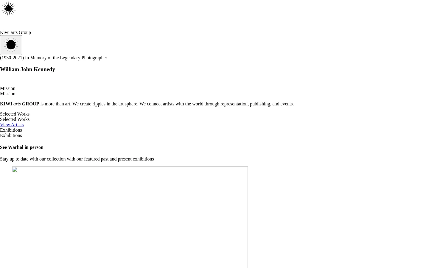 The desktop homepage for KIWI Arts Group features a minimalist white background with black text. The layout includes a memorial header for William John Kennedy, a mission statement section, a 'Selected Works' area with a 'View Artists' button, and an 'Exhibitions' section showcasing a grid of past exhibition images and titles.