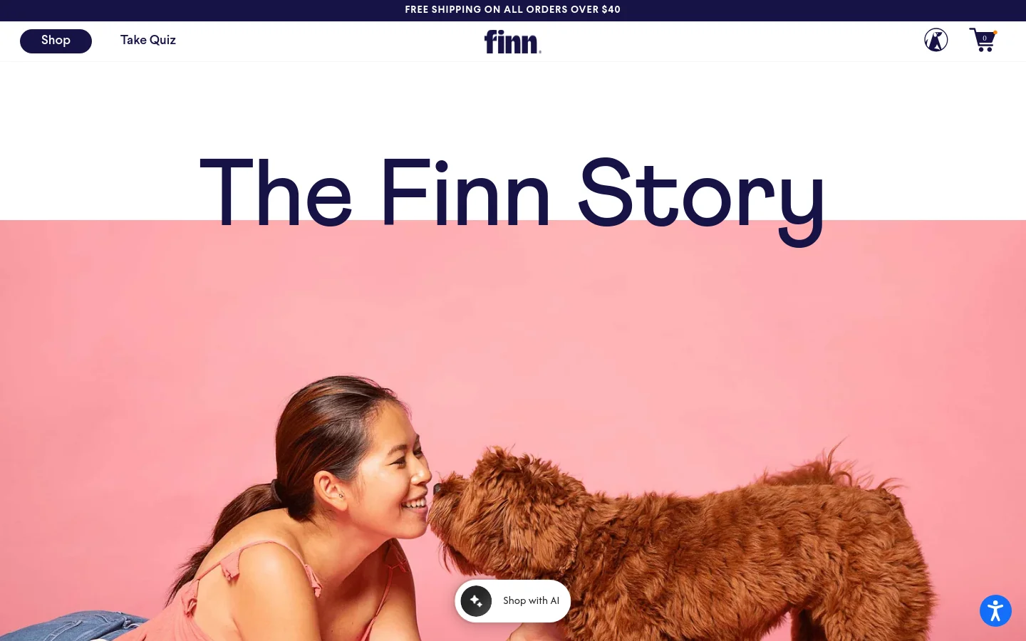 The About page features a large hero image of a woman smiling at a brown dog against a pink background, topped by the headline 'The Finn Story'. The layout uses a clean white background with dark blue text, showcasing sections about their mission, foster dog partnerships, and product quality with colorful lifestyle photography. Navigation includes a 'Shop' button, 'Take Quiz' link, and a shopping cart icon.