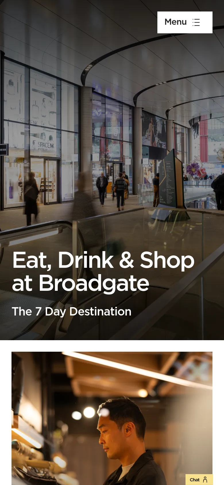 The mobile version shows the same hero image of the shopping mall interior and large white headline, but the navigation is condensed into a white 'Menu' button with a hamburger icon in the bottom right area. A small yellow 'Chat' button is also visible at the bottom of the screen.