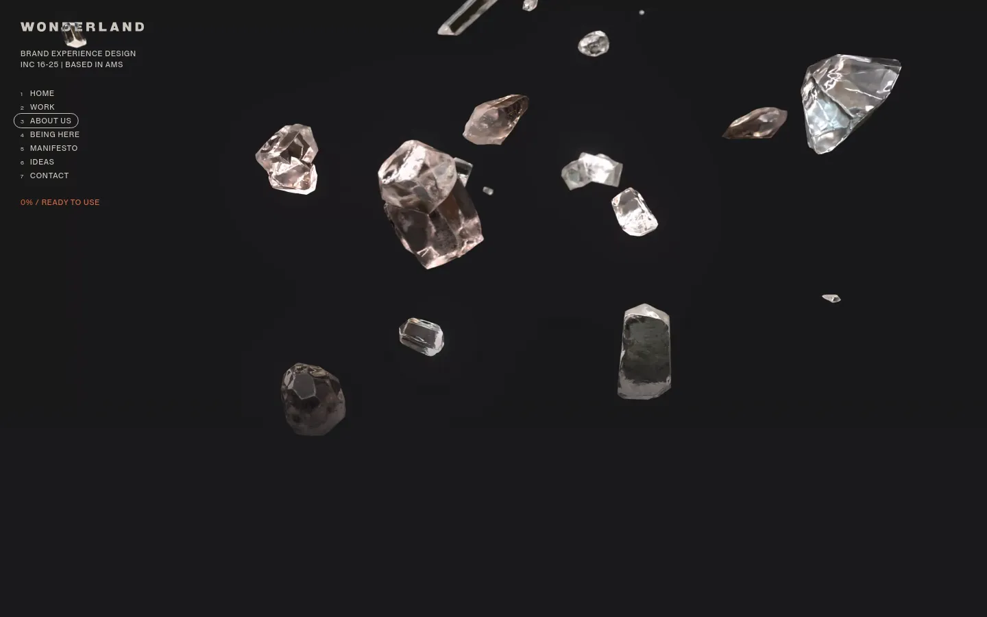 The desktop page features a dark minimalist layout with floating, translucent crystal fragments scattered across a black background. On the left, white sans-serif text displays the studio name, 'WONDERLAND', followed by a vertical navigation menu where '3 ABOUT US' is highlighted in a pill-shaped outline. The overall aesthetic is high-contrast and cinematic.