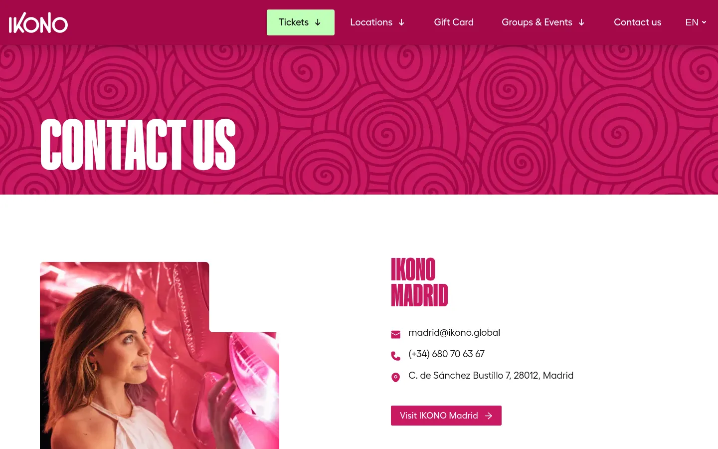 The Contact Us page features a vibrant pink hero banner with a swirling pattern and large white text. Below, location sections are arranged with a large lifestyle photo on the left and contact details for specific cities like Madrid on the right, including email, phone, and address. The navigation bar at the top includes links for Tickets, Locations, Gift Card, Groups & Events, and Contact Us.