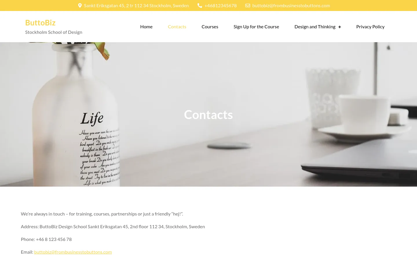 The desktop Contacts page features a large hero image of a white vase with flowers and a laptop on a desk, overlaid with the white headline 'Contacts'. Below the hero, a clean white section displays contact details including the address, phone number, and email address in dark text. A yellow top bar contains the physical address, phone number, and email icon.