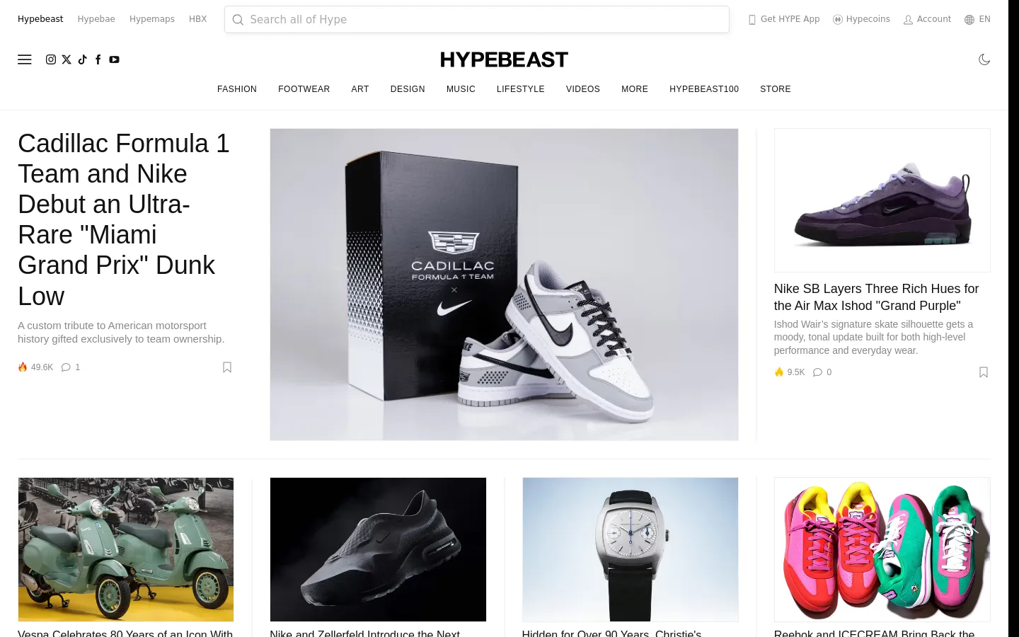 The Hypebeast desktop homepage features a clean, white minimalist layout with a top navigation bar containing categories like Fashion, Footwear, and Art. The hero section highlights a large feature story about a Cadillac and Nike collaboration with a prominent image of a white and grey sneaker next to a branded box. Below the hero, a grid of smaller articles displays various streetwear and lifestyle topics with high-quality photography.