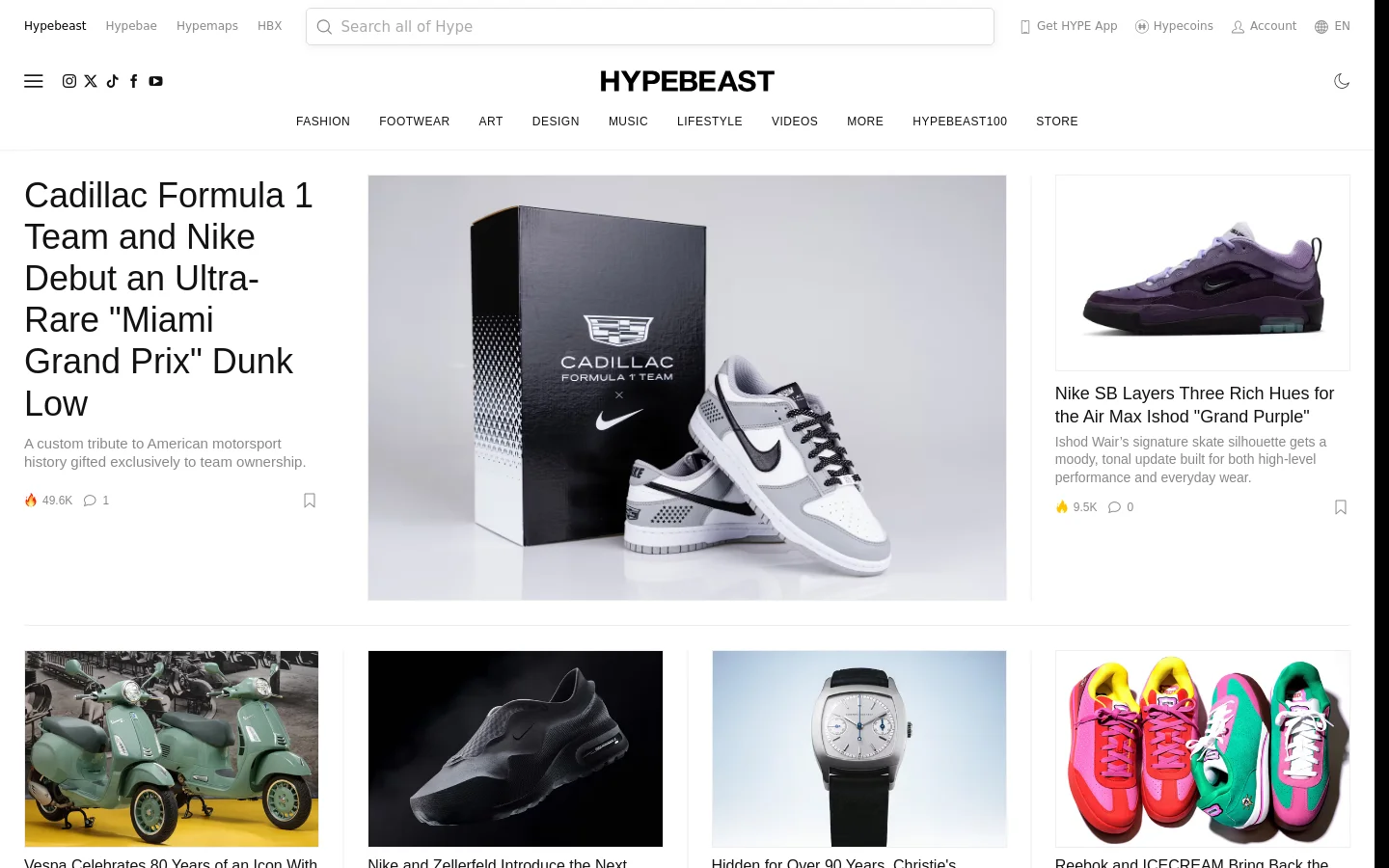 The Hypebeast desktop homepage features a clean, white minimalist layout with a top navigation bar containing categories like Fashion, Footwear, and Art. The hero section highlights a large feature story about a Cadillac and Nike collaboration with a prominent image of a white and grey sneaker next to a branded box. Below the hero, a grid of smaller articles displays various streetwear and lifestyle topics with high-quality photography.