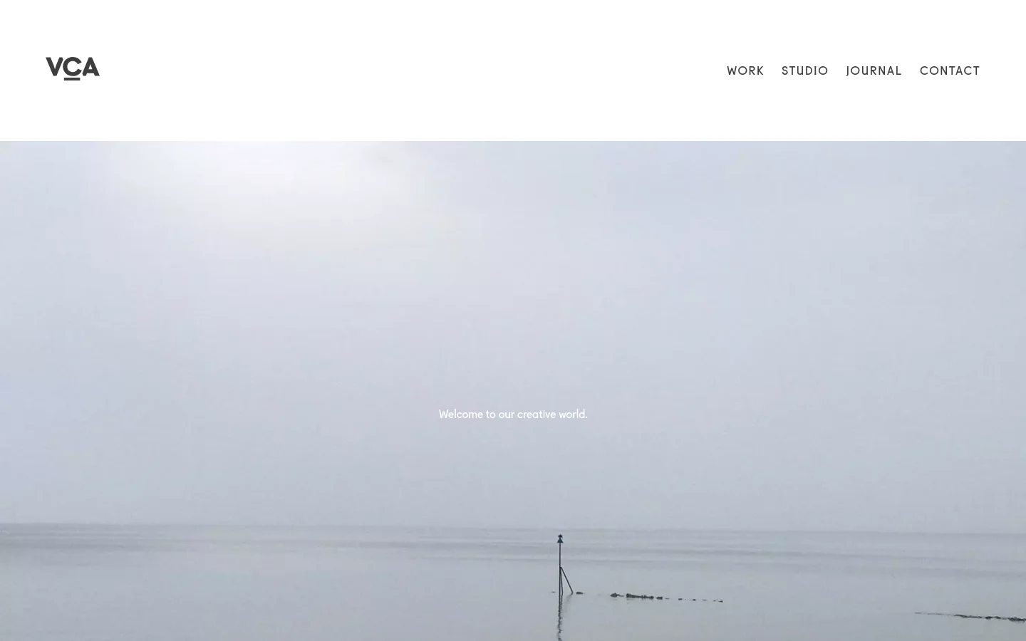 The desktop version features a minimalist white header with the VCA logo on the left and navigation links on the right. Below, a large hero image shows a misty, calm seascape with the text 'Welcome to our creative world.' centered in white.