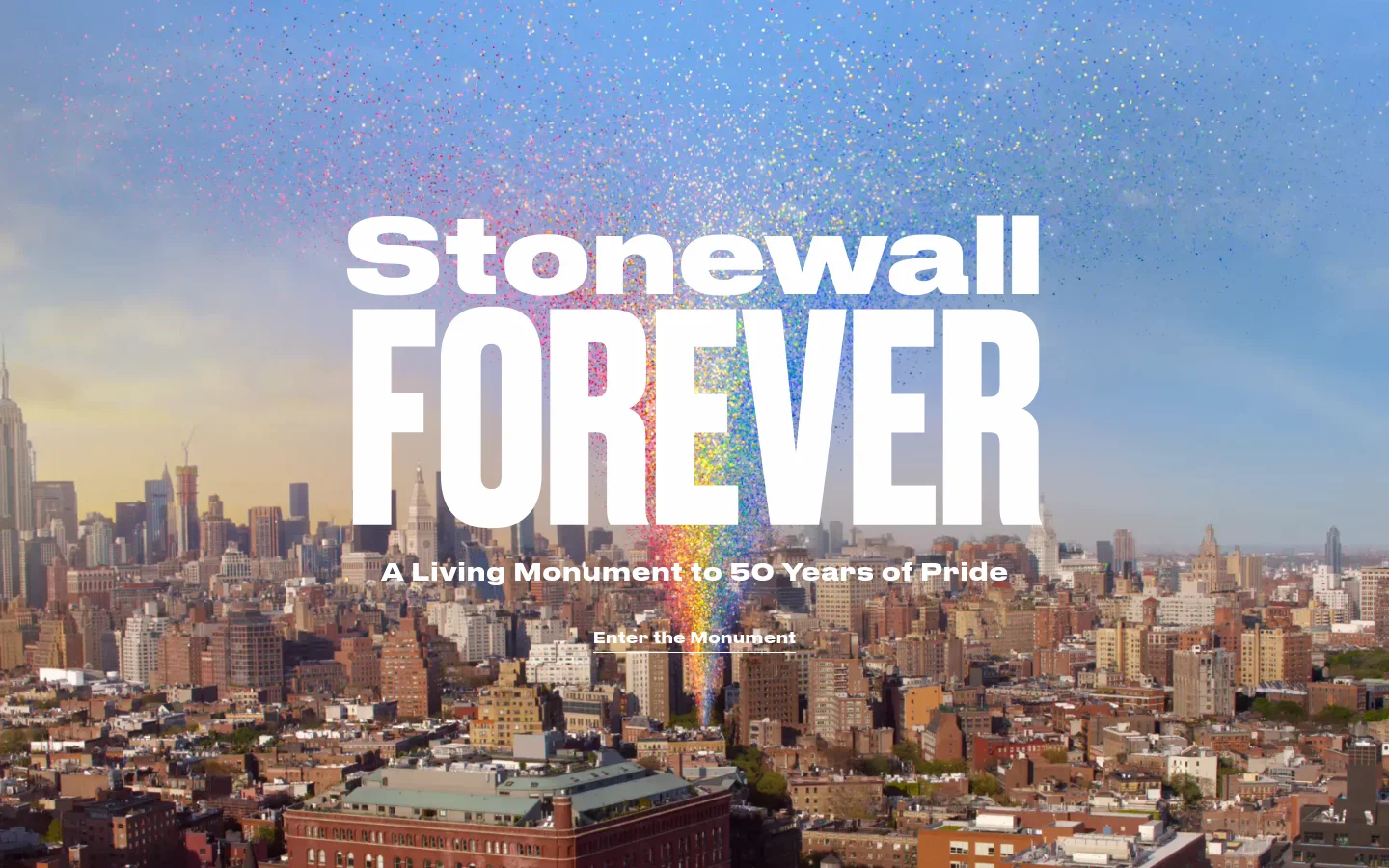 The desktop homepage features a large, cinematic cityscape of New York City under a bright blue sky with a rainbow-colored particle trail descending from the top. Large white text reads 'Stonewall FOREVER' above the subtitle 'A Living Monument to 50 Years of Pride,' with a primary 'Enter the Monument' call to action centered below.