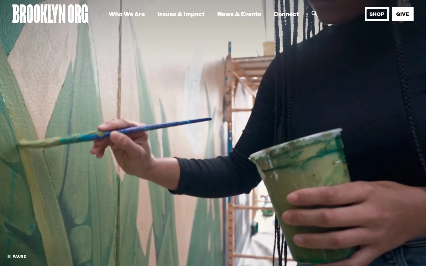 The desktop homepage features a large hero image of a person painting a mural, with the Brooklyn Org logo in white on the left. A navigation menu includes links for Who We Are, Issues & Impact, News & Events, and Connect, alongside 'Shop' and 'Give' buttons. The color palette is dominated by the vibrant colors of the mural art.