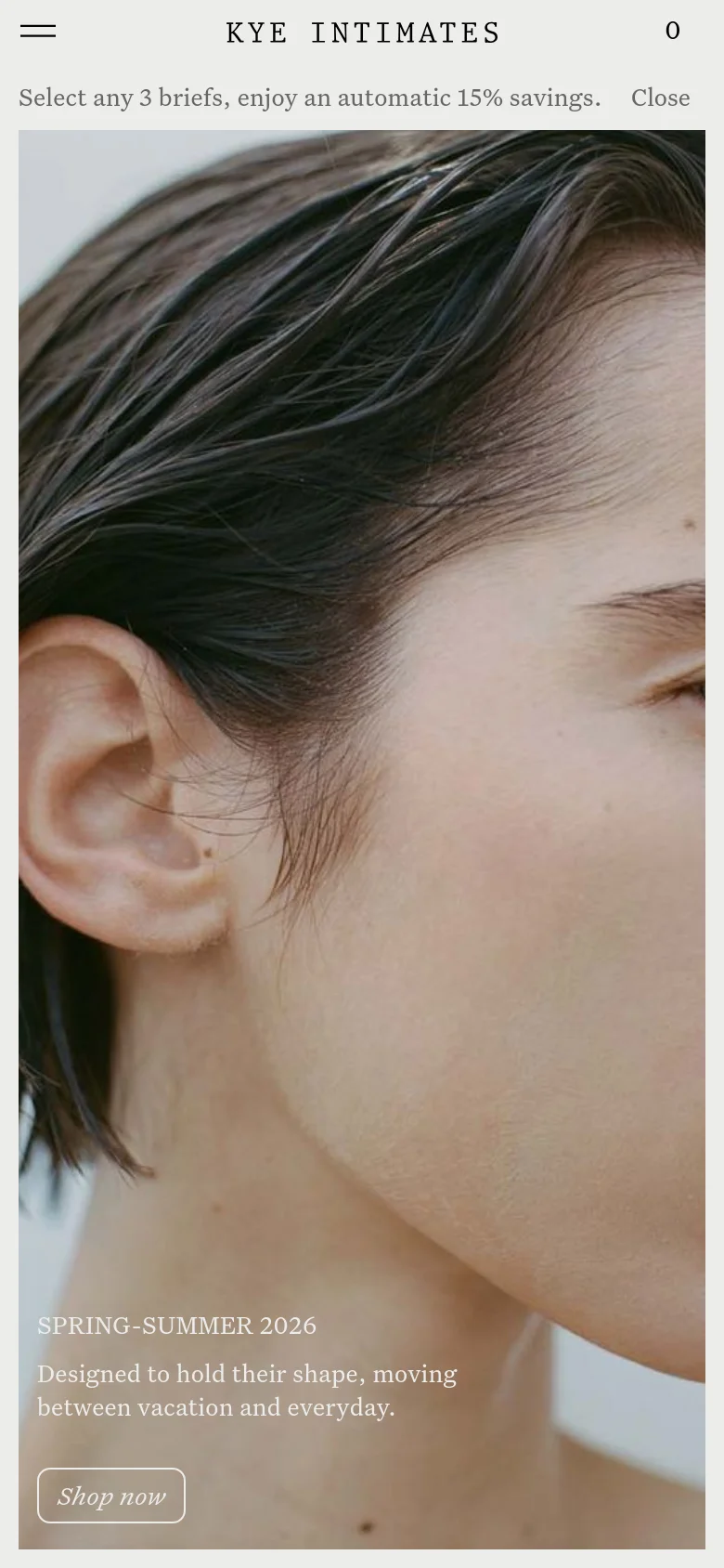 The mobile version presents a vertically oriented, close-up view of the hero imagery, focusing on the person's face and shoulder. The layout is simplified with a hamburger menu icon on the left, the brand name centered, and the promotional text and 'Shop now' button positioned at the bottom of the screen.