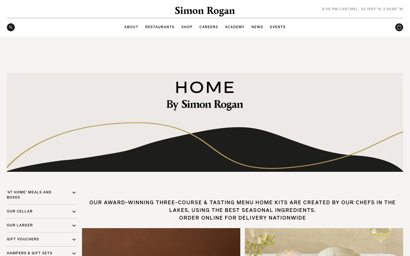 The desktop homepage for Home by Simon Rogan features a minimalist design with a large hero banner containing the title 'HOME By Simon Rogan' over a stylized black and gold landscape graphic. Below the banner, a text block describes award-winning home kits, and a left-hand sidebar provides navigation links for 'At Home' Meals, Our Cellar, Our Larder, and Gift Vouchers.