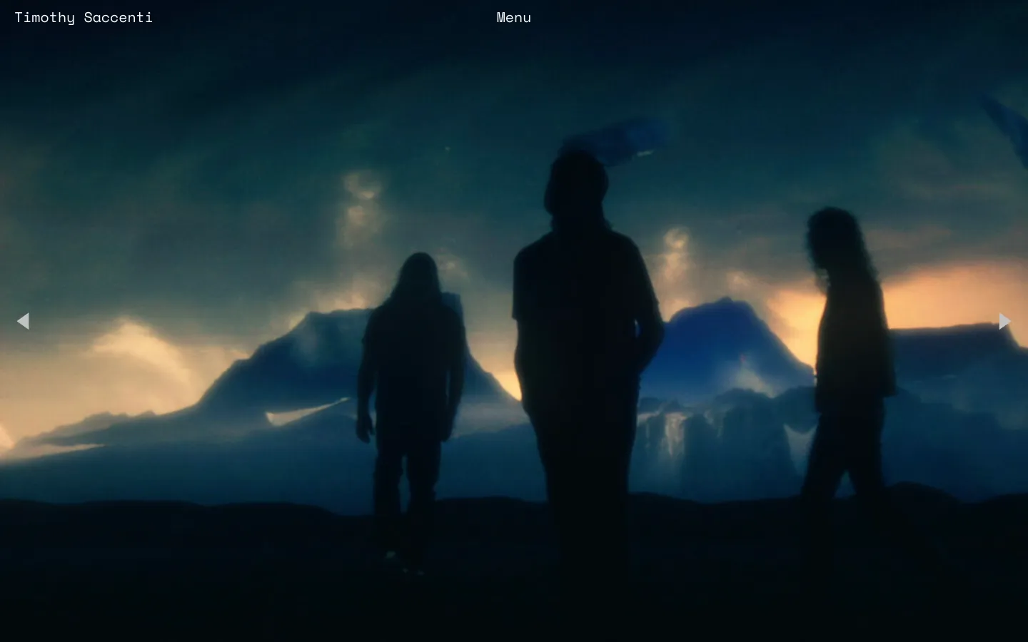 The desktop homepage features a cinematic, wide-angle hero image of three silhouetted figures standing against a dramatic landscape of mountains and a glowing sunset sky. The name 'Timothy Saccenti' is in the top left and a 'Menu' button is in the top right, both in white text over the dark, moody blue and orange background.