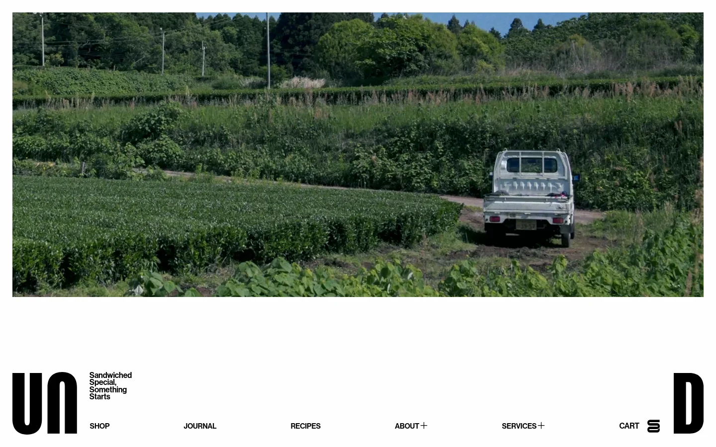 The desktop homepage features a minimalist design with large black typography for 'UN' and 'D' flanking the navigation menu. A hero section displays high-quality imagery of Japanese tea fields and a white truck, followed by sections for Bakery and Almond Milk Bread with large, full-width lifestyle photos. The layout uses ample white space and a clean, modern aesthetic with black text on a white background.
