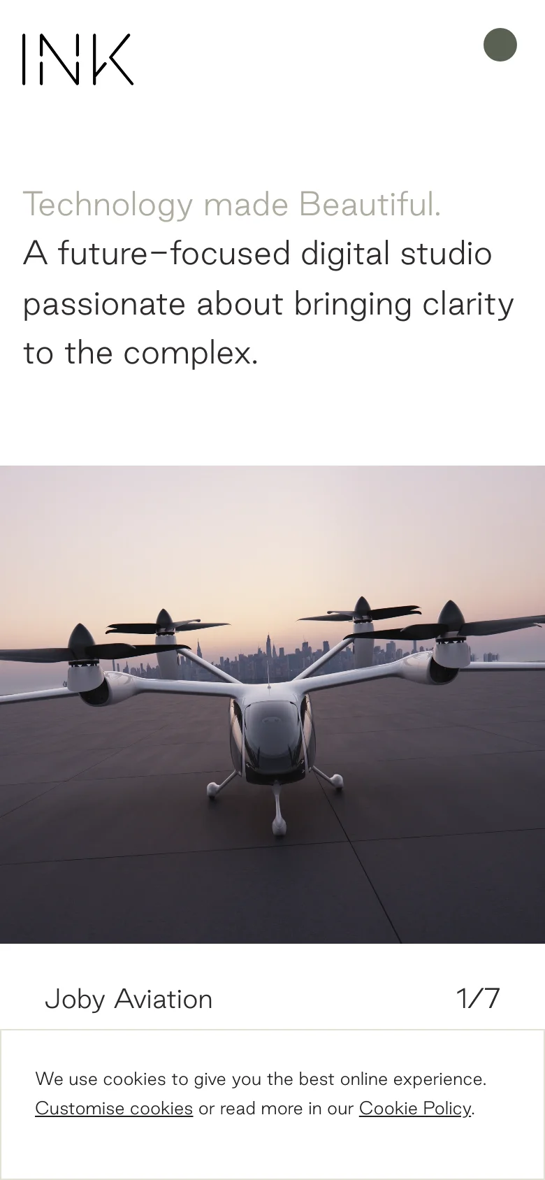 The mobile version maintains the minimalist aesthetic with the logo and menu icon at the top. The text is stacked vertically to fit the narrow screen, and the hero image carousel occupies the full width of the viewport. A cookie consent banner appears at the bottom of the screen.