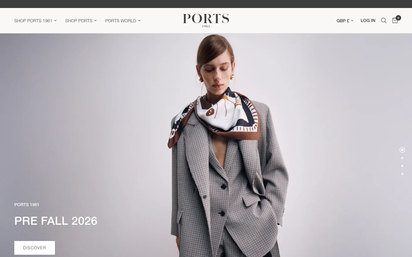 The desktop homepage features a minimalist white navigation bar with the PORTS 1961 logo centered. A large hero image shows a model in a grey checked suit and patterned scarf, with the headline 'PRE FALL 2026' and a 'DISCOVER' button overlaid on the left. The layout is clean with ample white space and high-fashion imagery.