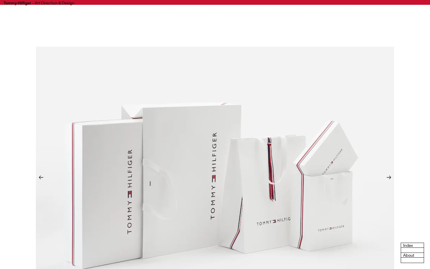 A desktop webpage for the Tommy Hilfiger rebranding project featuring a large hero image of white branded shopping bags and boxes against a light background. The layout includes a red header with the project title, a large text block describing the design work, and a minimalist navigation interface with arrows and an index.