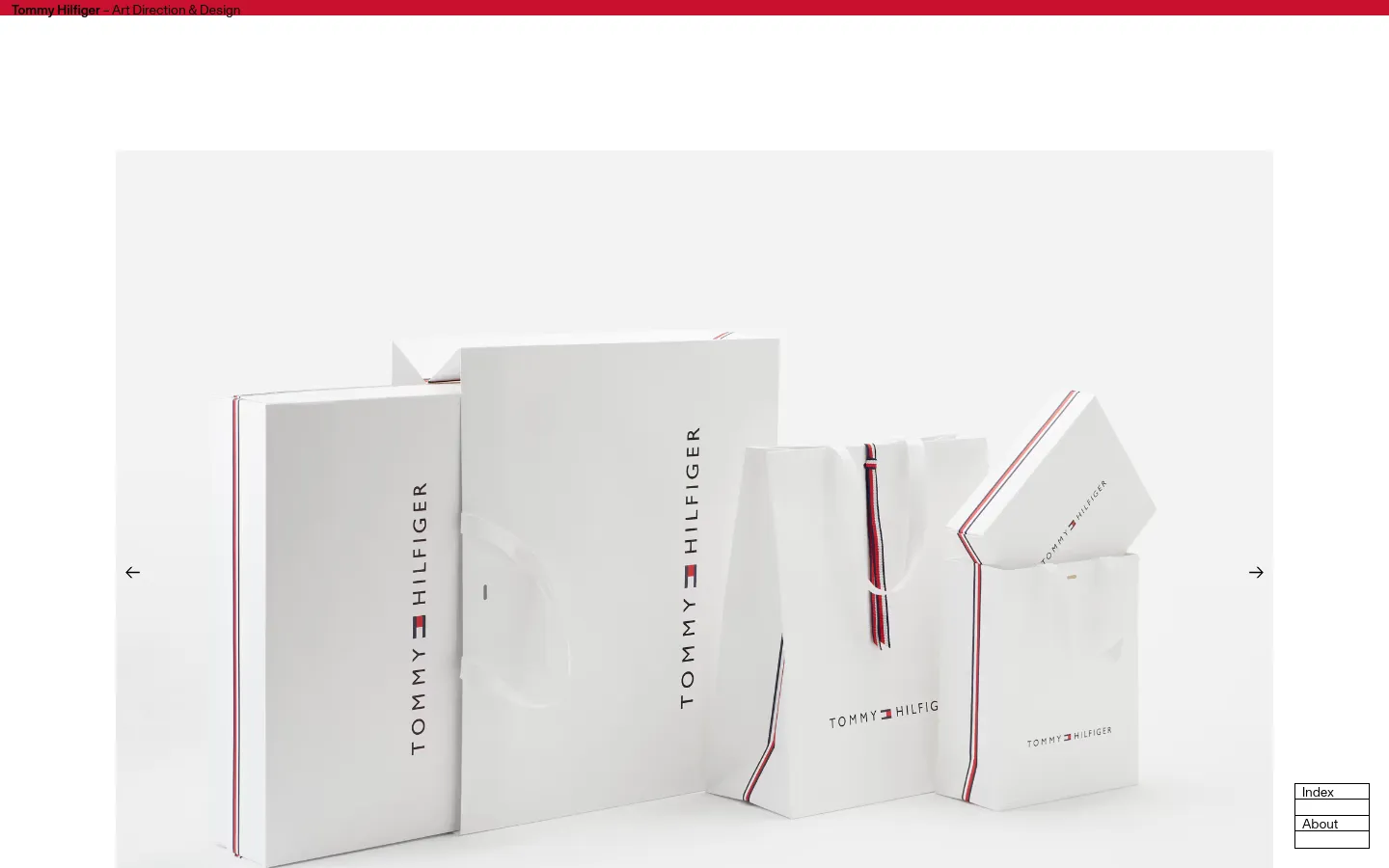 A desktop webpage for the Tommy Hilfiger rebranding project featuring a large hero image of white branded shopping bags and boxes against a light background. The layout includes a red header with the project title, a large text block describing the design work, and a minimalist navigation interface with arrows and an index.