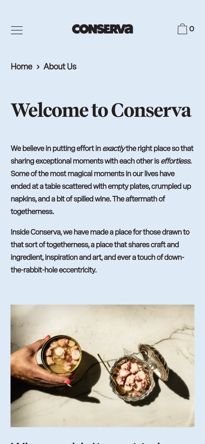 The mobile version uses a simplified single-column layout with a hamburger menu icon and the Conserva logo centered at the top. The text and large hero image of seafood tins on marble are stacked vertically, making the content easier to scroll through on a smaller screen.