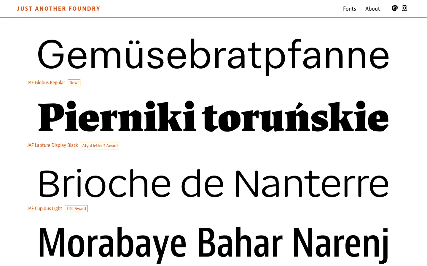 The homepage for Just Another Foundry features a minimalist white background with orange and black text. Large typographic specimens of various fonts, such as 'Gemüsebratpfanne' and 'Pierniki toruńskie', are stacked vertically, each accompanied by its font name and award badges. The navigation bar at the top includes links for 'Fonts' and 'About' alongside social media icons.