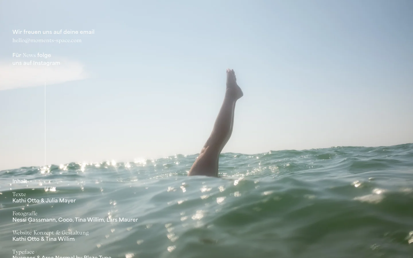 The contact page features a large, serene hero image of a person's legs extending upwards from sparkling ocean water against a pale sky. Minimalist white text overlays the left side, providing an email address and an Instagram link. A navigation menu is at the top, and detailed credits for text, photography, and design are listed at the bottom in white font.