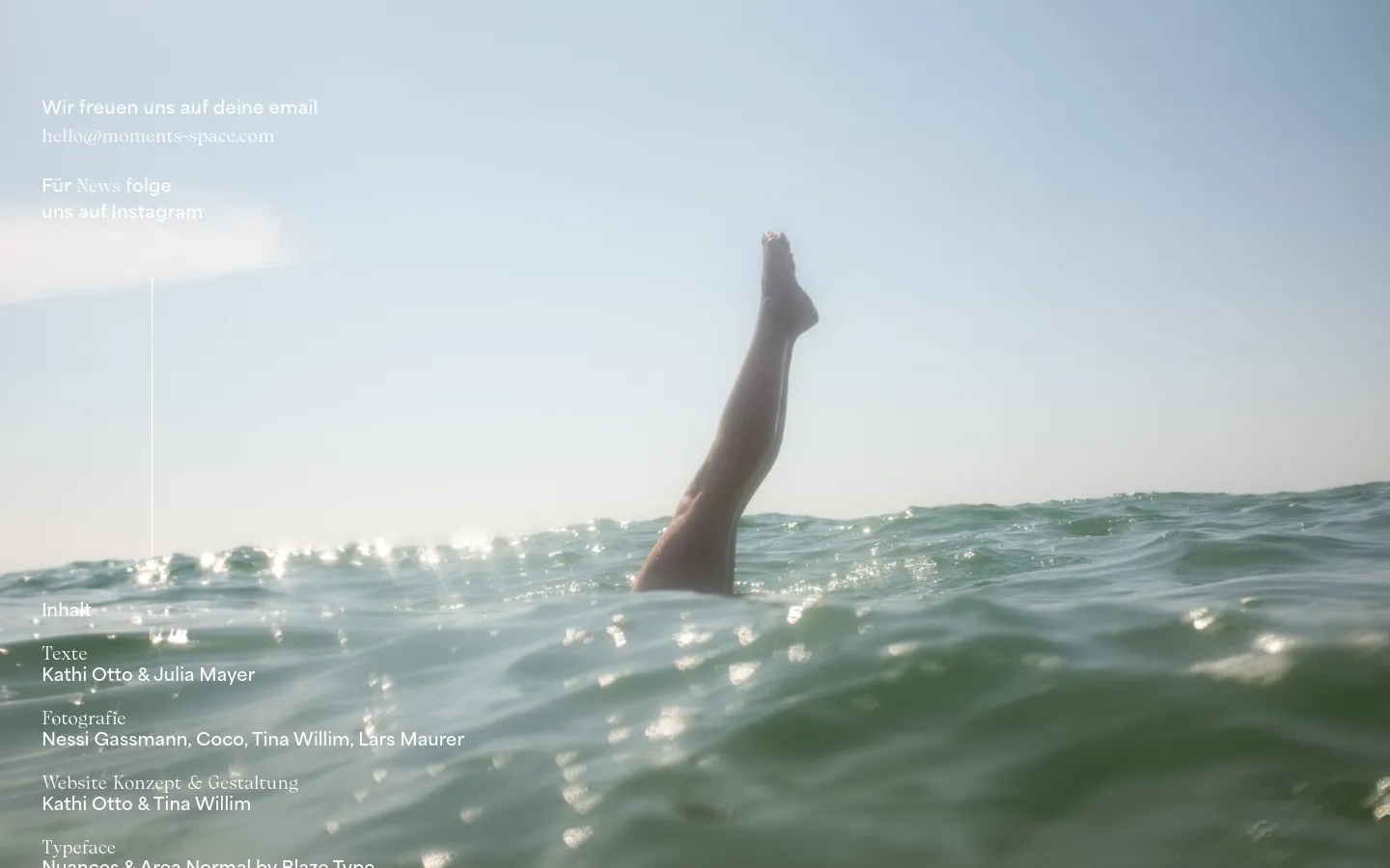 The contact page features a large, serene hero image of a person's legs extending upwards from sparkling ocean water against a pale sky. Minimalist white text overlays the left side, providing an email address and an Instagram link. A navigation menu is at the top, and detailed credits for text, photography, and design are listed at the bottom in white font.