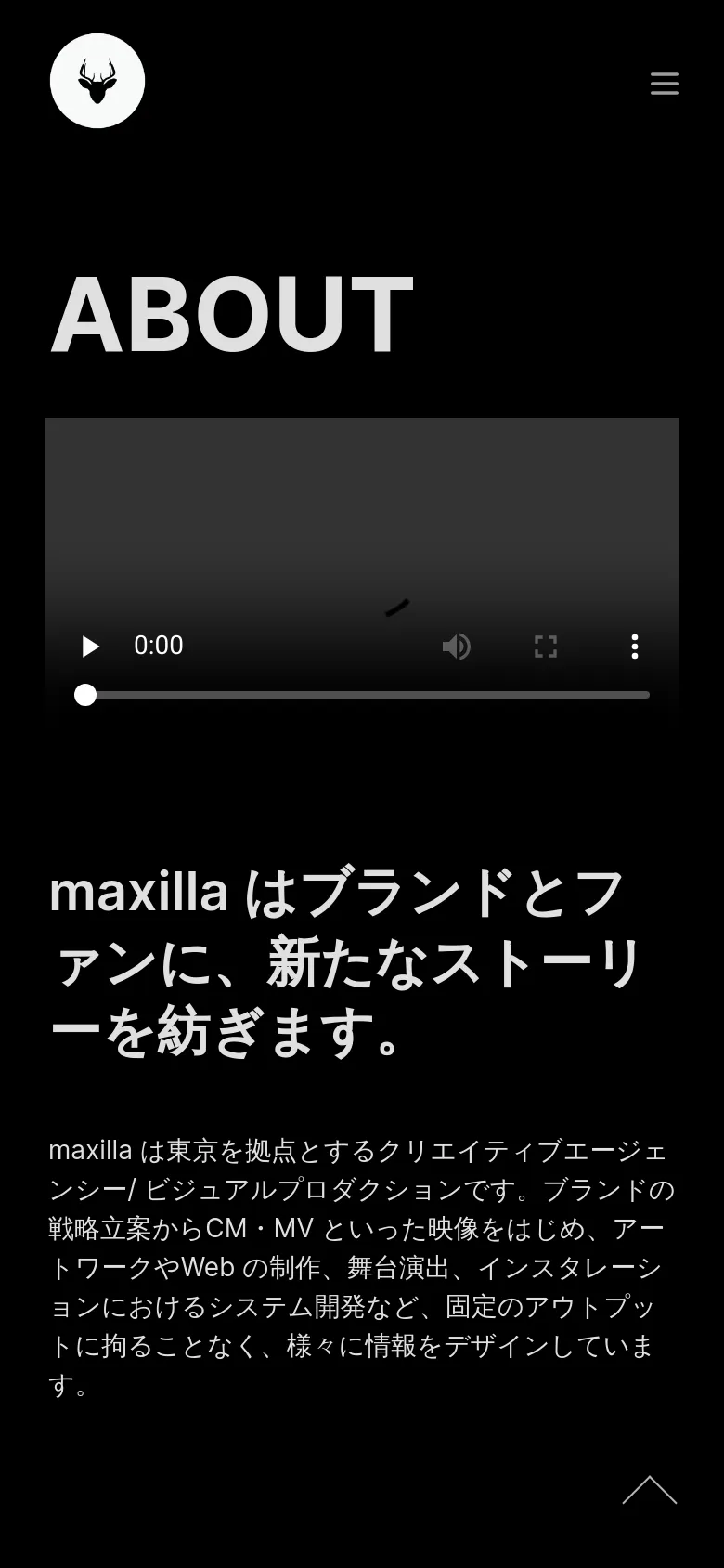 The mobile version maintains the dark theme but uses a simplified layout with a hamburger menu icon in the top right. The large 'ABOUT' title and video player are stacked vertically above the Japanese text, which is formatted for a narrower screen width. A circular logo remains in the top left, and a scroll-to-top arrow is visible at the bottom.