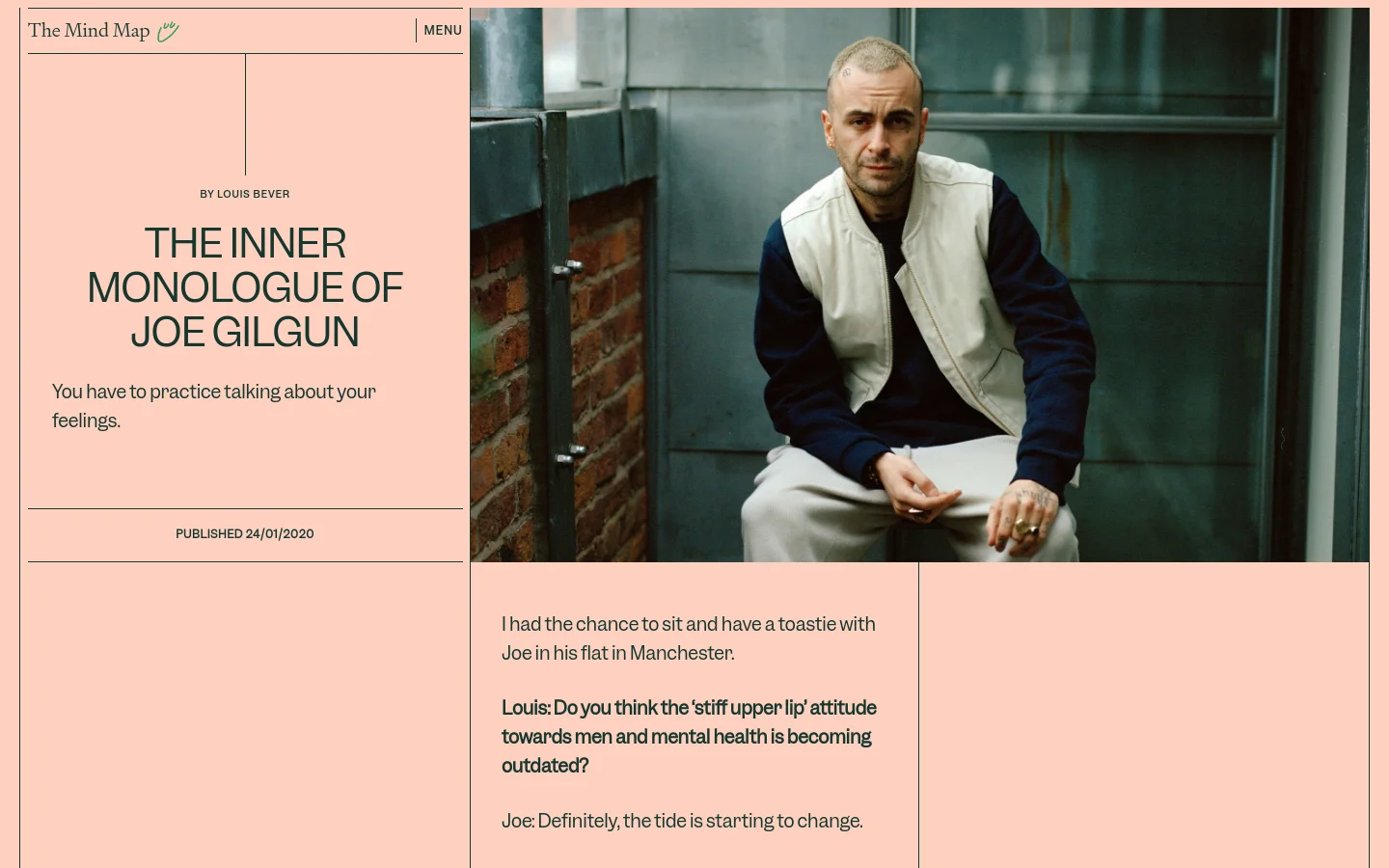 A desktop webpage with a split-screen layout featuring a peach-colored background on the left and a large photograph on the right. The left side contains the headline 'THE INNER MONOLOGUE OF JOE GILGUN' in bold black capital letters, the author name 'BY LOUIS BEVER', and the publication date. The right side shows a portrait of Joe Gilgun wearing a white vest over a dark long-sleeve shirt, sitting outdoors.