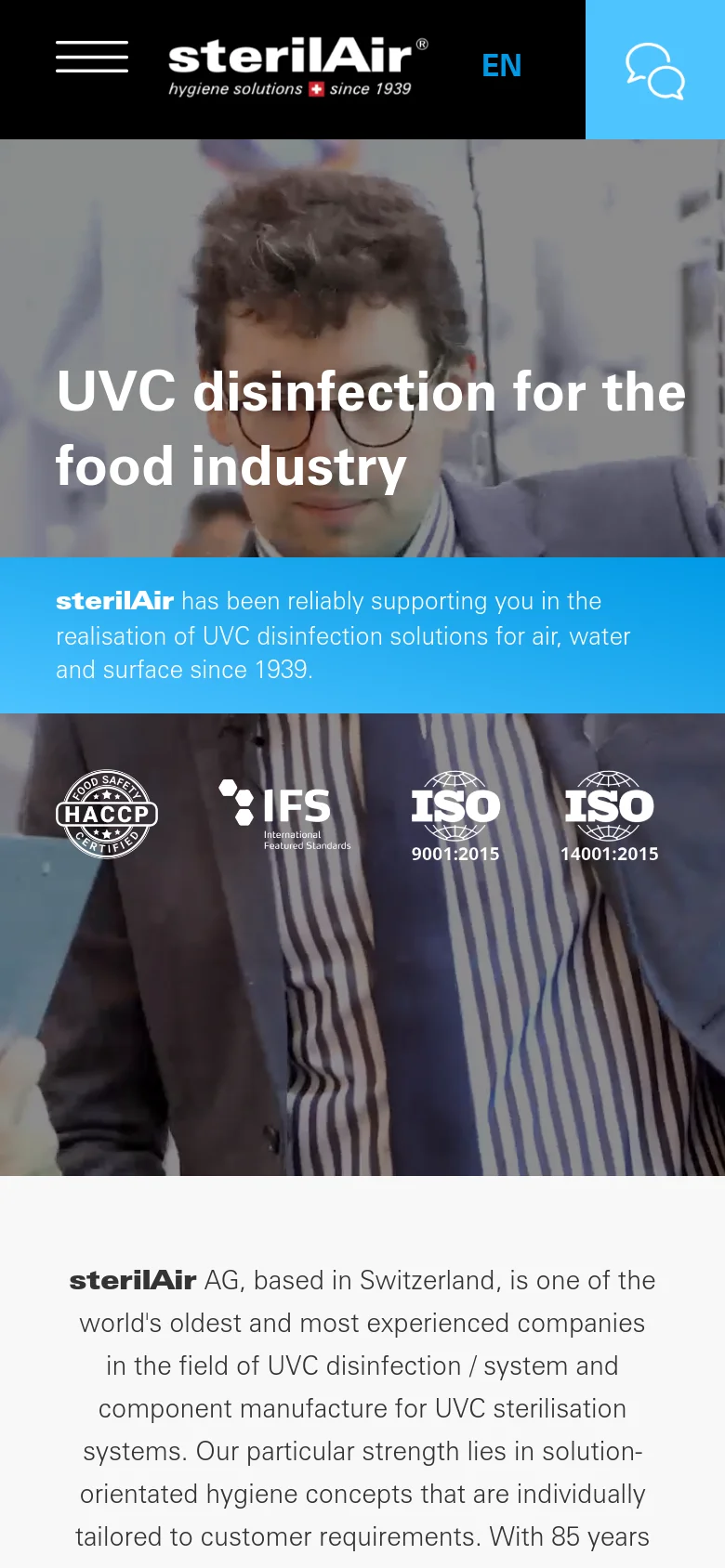 The mobile version presents a vertically stacked layout with a condensed header containing a hamburger menu, the company logo, and a language selector. The hero section features the same headline and blue banner, but the certification logos and background imagery are scaled to fit the narrower screen width.