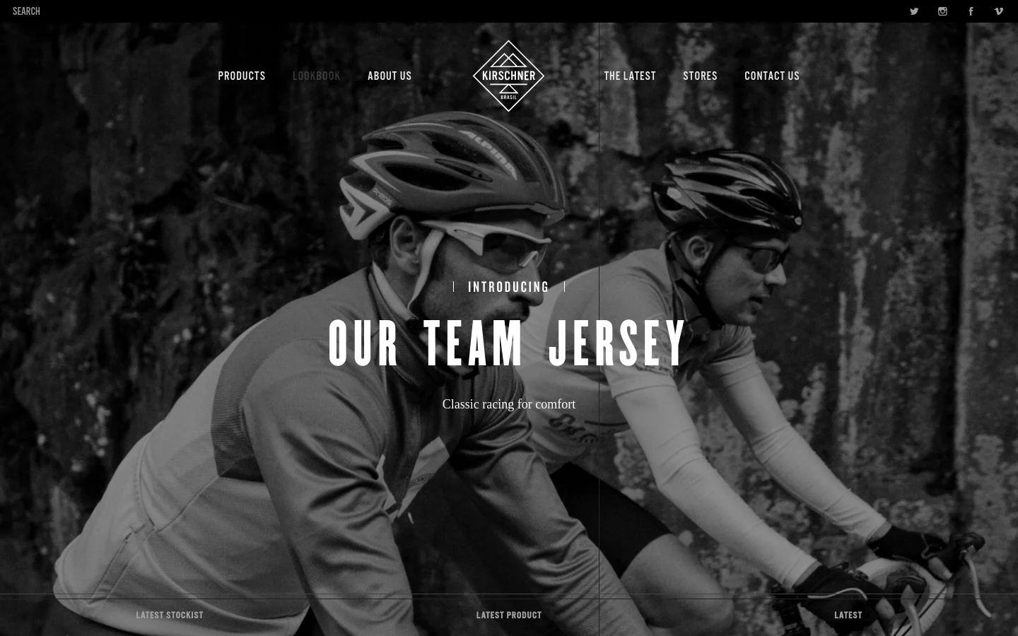 The desktop homepage features a large, black-and-white hero image of two cyclists in gear. A centered navigation menu includes links for Products, Lookbook, About Us, The Latest, Stores, and Contact Us, with the Kirschner logo positioned above. The hero section displays the headline 'INTRODUCING OUR TEAM JERSEY' and a 'LATEST STOCKIST' call to action at the bottom.