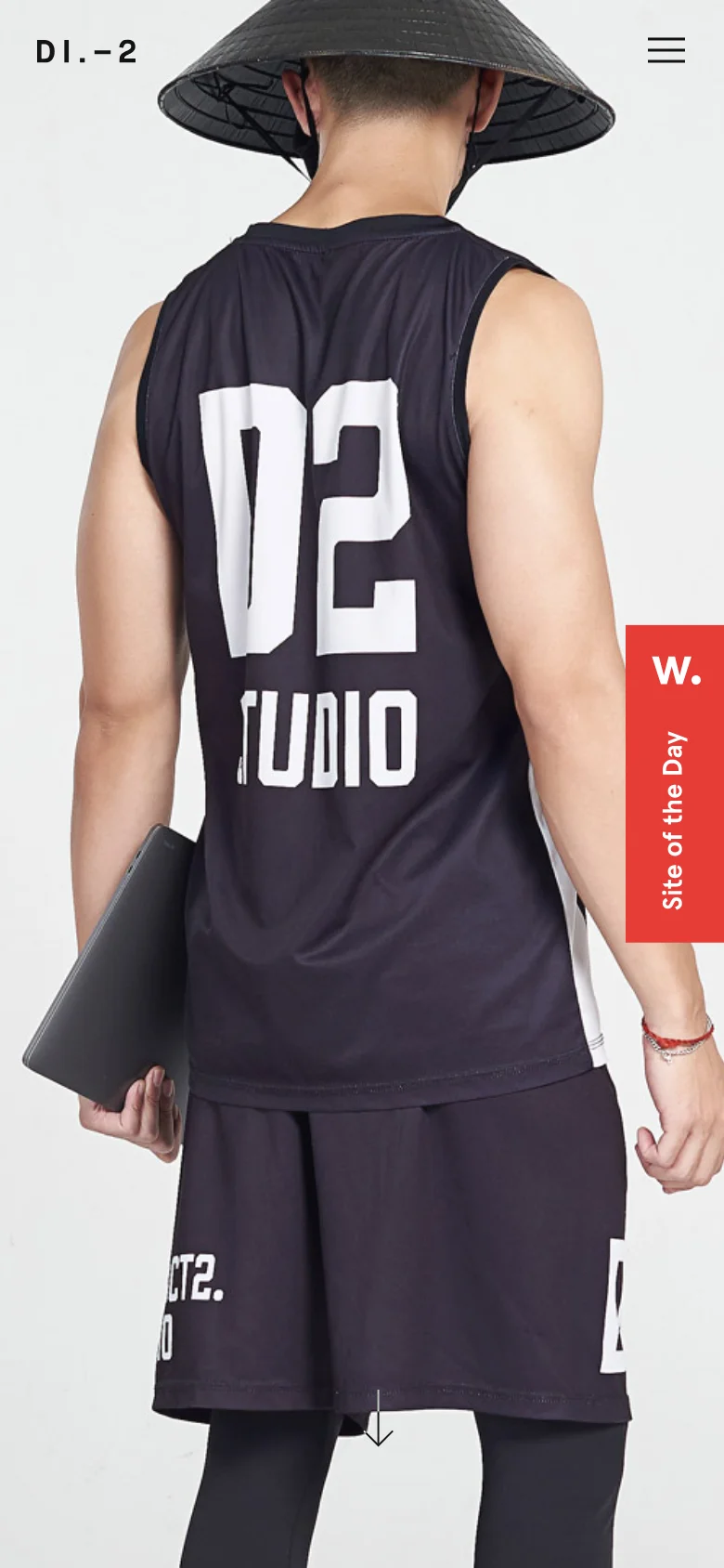 The mobile version simplifies the layout, focusing on a large, vertically oriented hero image of a person in a black 'D2 STUDIO' tank top and a conical hat. The navigation is condensed into a hamburger menu icon at the top right, and the 'Site of the Day' red tab remains visible on the right side of the screen.