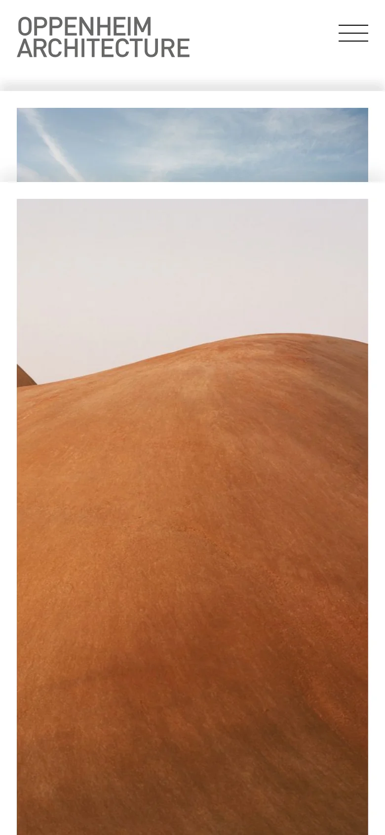 The mobile version maintains the minimalist aesthetic, focusing on the large desert dune imagery that fills the screen. The navigation is condensed into a hamburger menu at the top right, and the brand name is positioned prominently above the main visual content.
