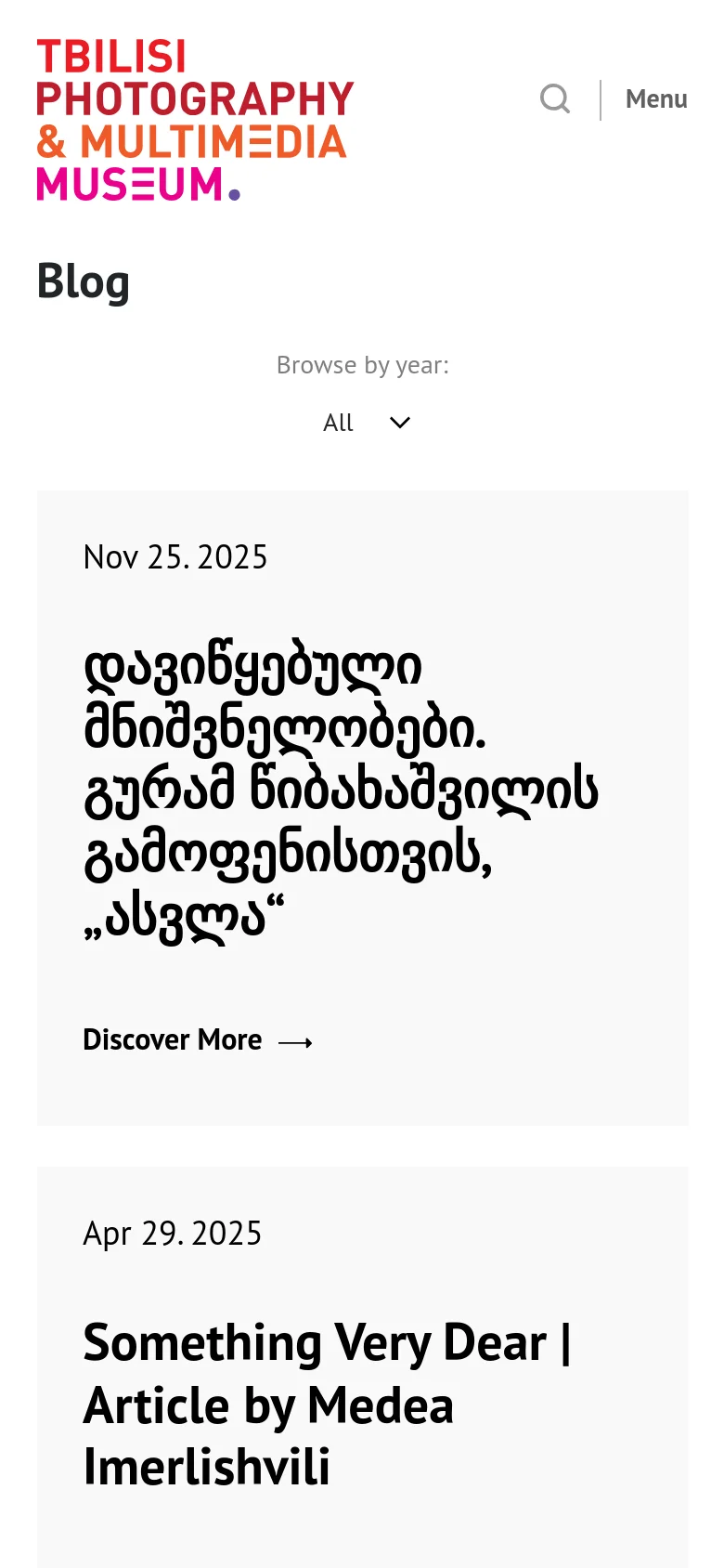The mobile version simplifies the layout, centering the museum logo and replacing the horizontal navigation with a 'Menu' button and a search icon. The blog posts are stacked vertically in a single column, showing the date, title, and 'Discover More' link for each entry to optimize for vertical scrolling on smaller screens.