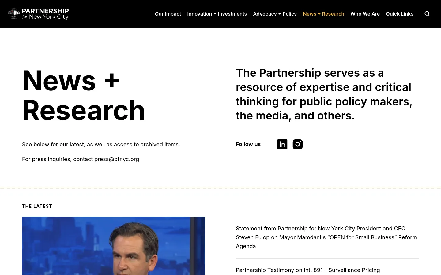The desktop page features a clean white and black layout with a navigation bar at the top. A large headline 'News + Research' sits on the left, balanced by a mission statement and social media icons on the right. Below, 'The Latest' section displays a featured news item with a large image of a man being interviewed, followed by a list of text-based news links.