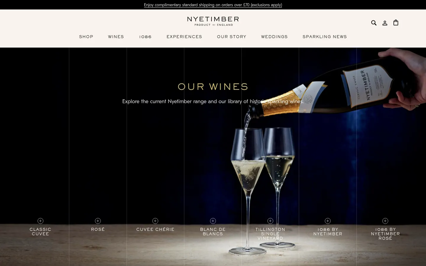 The desktop page features a dark, elegant hero image of sparkling wine being poured into glasses, overlaid with the headline 'OUR WINES'. Below the hero section, a horizontal row of clickable wine varieties includes Classic Cuvee, Rosé, and others, each represented by a bottle image and a plus icon.