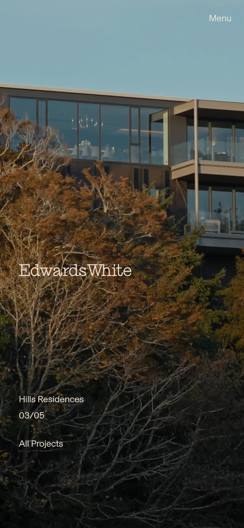 The mobile version displays a vertically oriented hero image of a modern building partially obscured by autumn-colored trees. The 'Edwards White' logo is prominently centered, with 'Menu' located in the top right and 'All Projects' acting as a primary call to action at the bottom. The layout is simplified to a single column to suit a smaller screen.