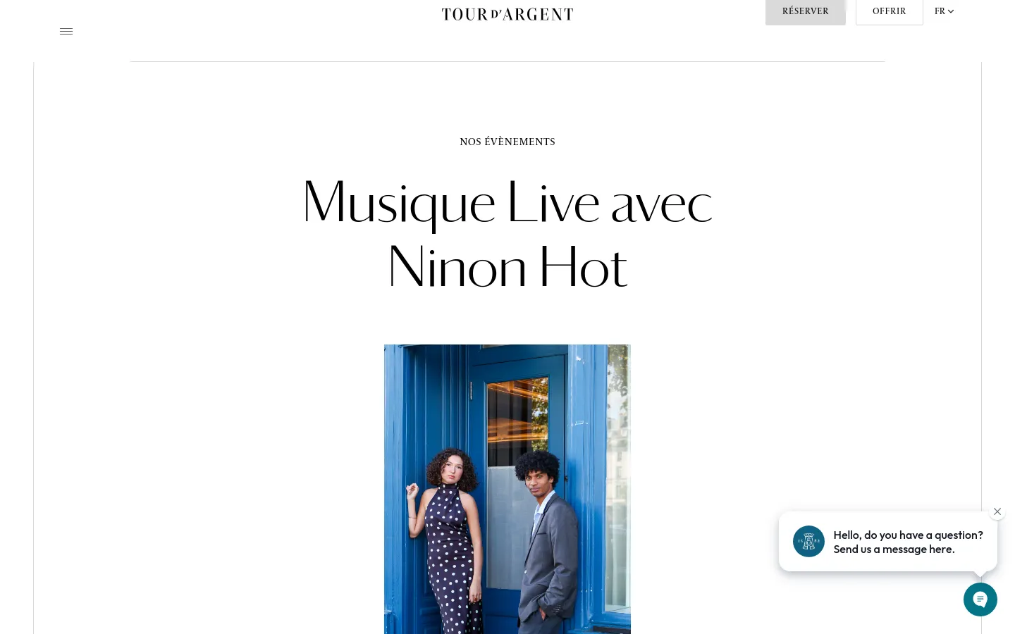 The desktop page features a minimalist white background with the headline 'NOS ÉVÈNEMENTS' and a large, elegant serif title 'Musique Live avec Ninon Hot'. Below the text, a vertical portrait shows two people posing in front of a bright blue door, with a floating chat widget in the bottom right corner.