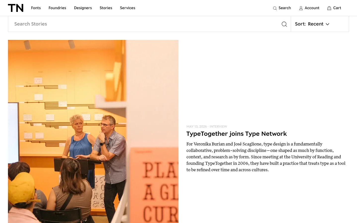 The Stories page features a clean, minimalist layout with a white background and black text. A search bar and a sort dropdown are positioned at the top, followed by a large featured article with a high-quality photograph of two people in a workshop setting. Below the hero article, a list of recent stories includes large rectangular images, dates, categories, headlines, and short text excerpts.