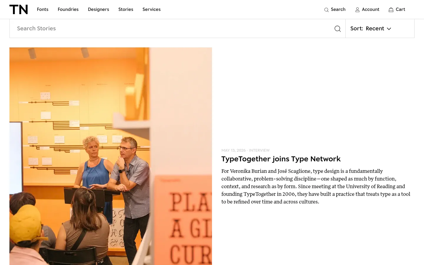 The Stories page features a clean, minimalist layout with a white background and black text. A search bar and a sort dropdown are positioned at the top, followed by a large featured article with a high-quality photograph of two people in a workshop setting. Below the hero article, a list of recent stories includes large rectangular images, dates, categories, headlines, and short text excerpts.