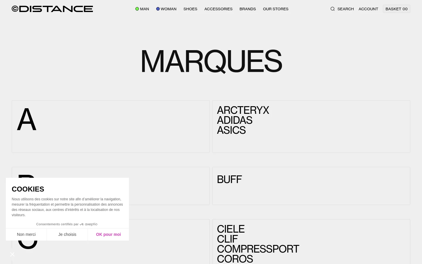 The desktop page features a minimalist white background with the large heading 'MARQUES' at the top. Below, brand names are organized into a grid layout with large alphabetical section headers in light grey boxes. The navigation menu at the top includes links for Man, Woman, Shoes, Accessories, Brands, and Our Stores, alongside search and account options.