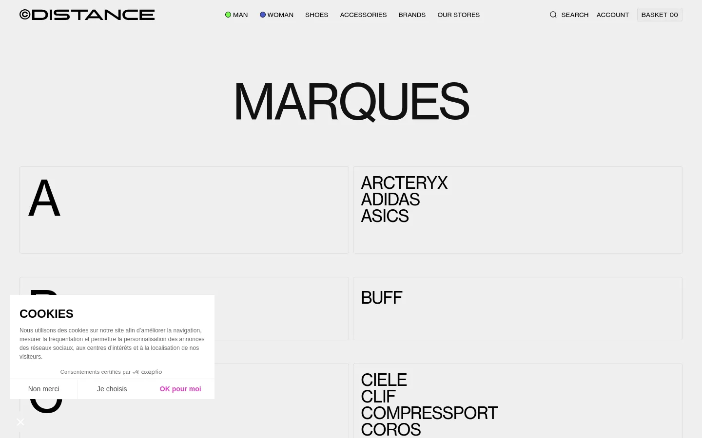 The desktop page features a minimalist white background with the large heading 'MARQUES' at the top. Below, brand names are organized into a grid layout with large alphabetical section headers in light grey boxes. The navigation menu at the top includes links for Man, Woman, Shoes, Accessories, Brands, and Our Stores, alongside search and account options.
