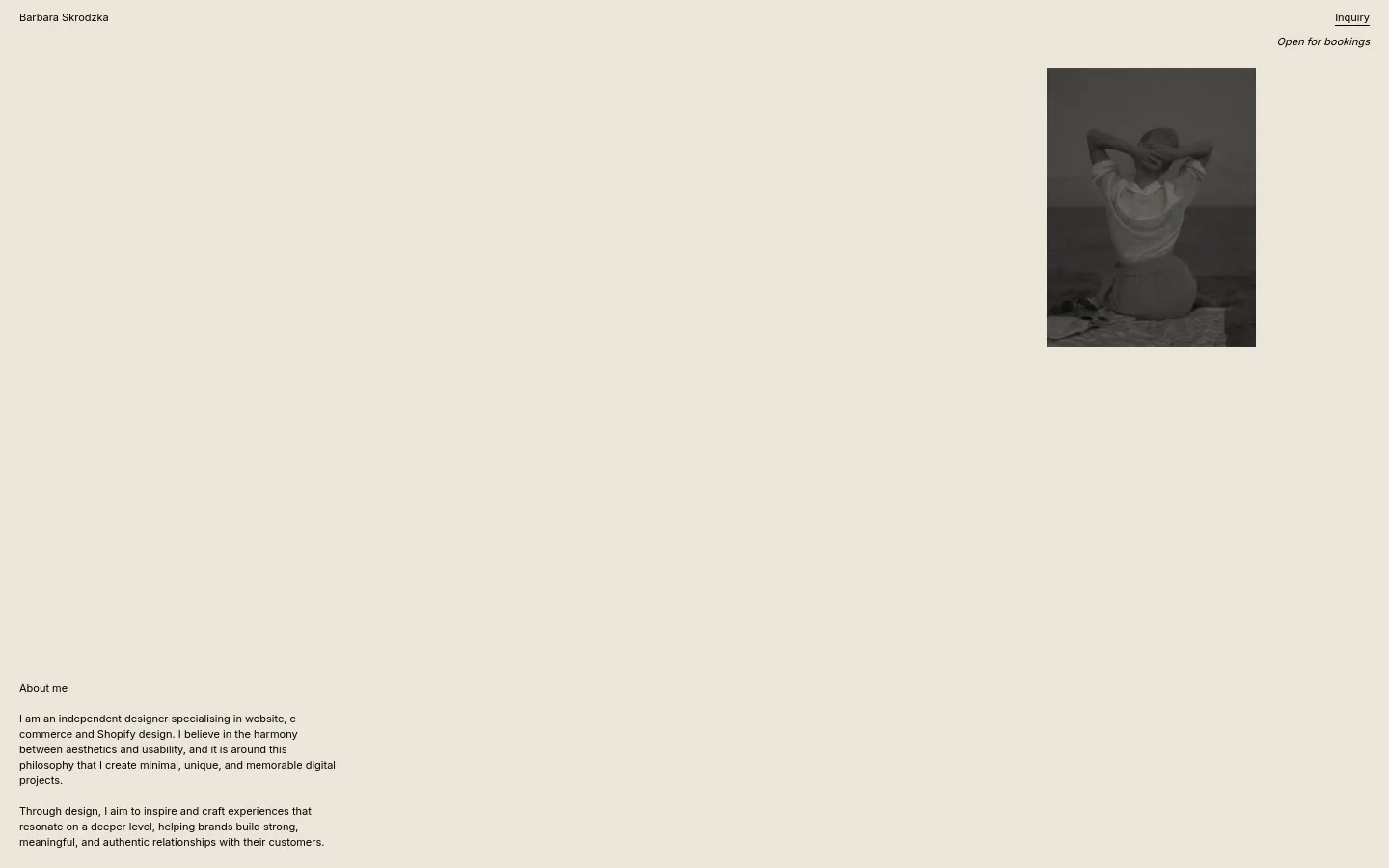 The desktop About Me page features a minimalist design with a light beige background and black serif typography. The layout consists of a header with the name 'Barbara Skrodzka' and an 'Inquiry' link, a large black and white portrait of a woman on the right, and biographical text on the left. A primary call to action, 'Open for bookings,' sits below the inquiry link.