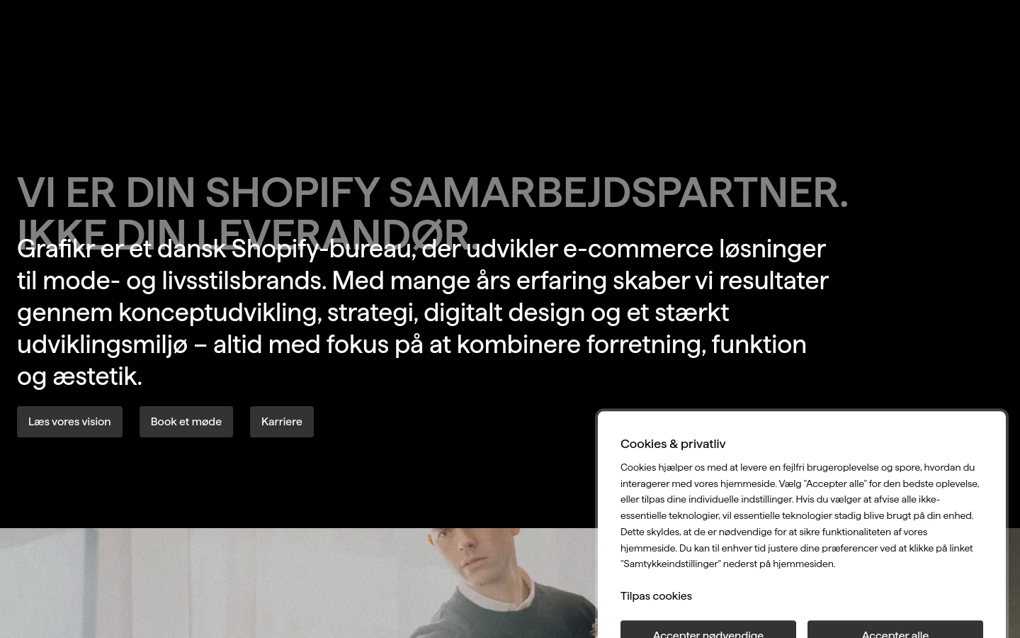 The desktop page features a dark hero section with large white text stating 'Vi er din Shopify samarbejdspartner. Ikke din leverandør.' followed by a descriptive paragraph and three call-to-action buttons. Below the hero, a large lifestyle photograph shows two men, and the layout uses a clean, minimalist aesthetic with high contrast between white text and a black background.