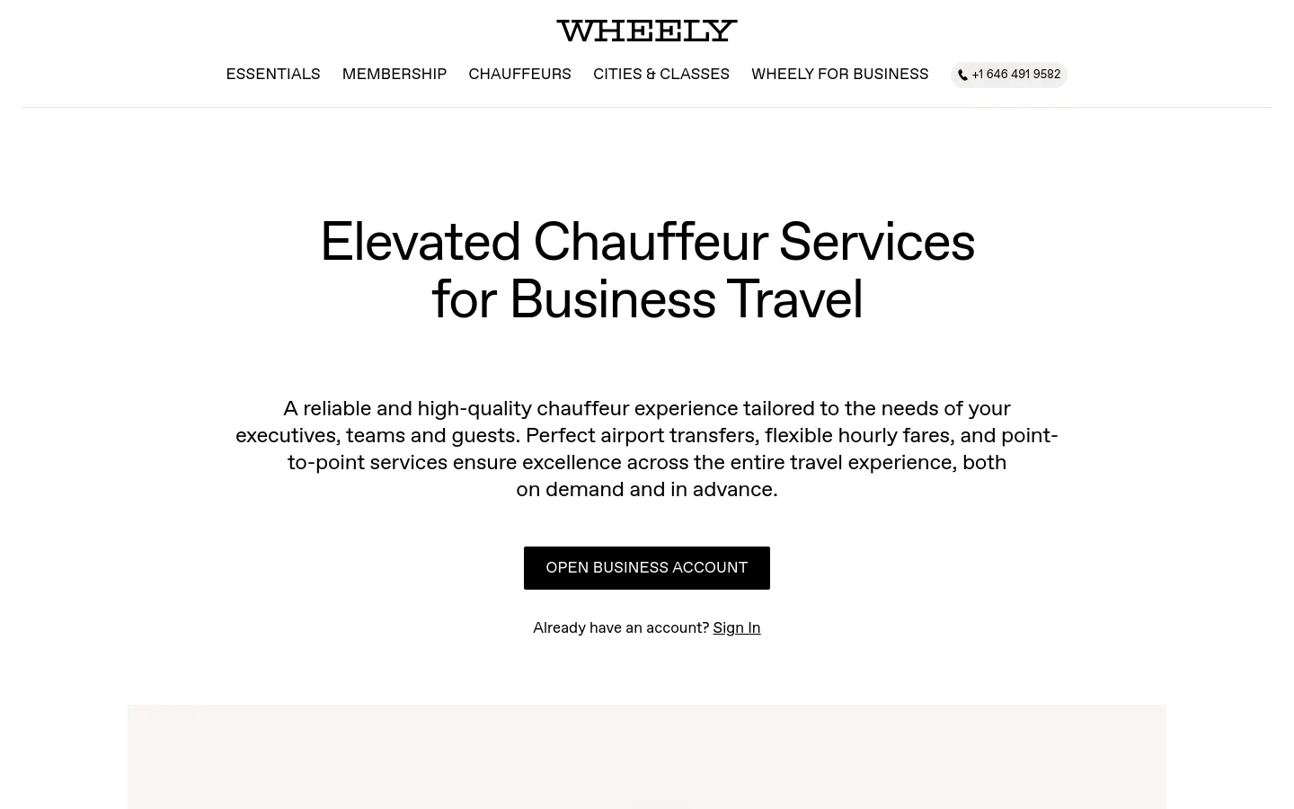 The desktop page features a clean, minimalist white background with the Wheely logo at the top center and a navigation menu below it. The hero section displays a large headline, 'Elevated Chauffeur Services for Business Travel,' followed by a descriptive paragraph and a prominent black 'OPEN BUSINESS ACCOUNT' button. A phone number contact button is located in the top right corner.