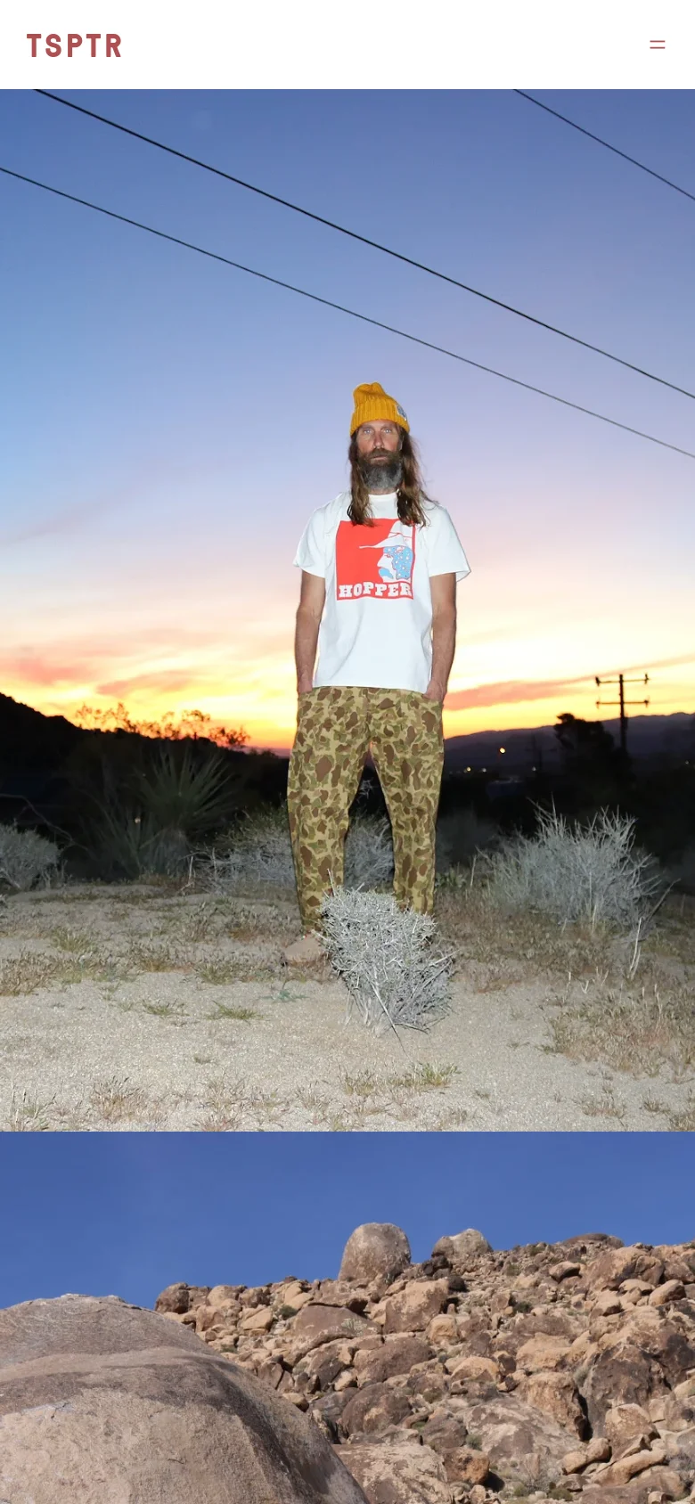 The mobile version maintains the minimalist aesthetic with a simplified header featuring the 'TSPTR' logo and a hamburger menu icon on the right. The hero image of the man in the desert is scaled to fit the vertical screen, emphasizing the sunset colors and the landscape. The layout is streamlined for vertical scrolling, focusing on large-scale imagery.
