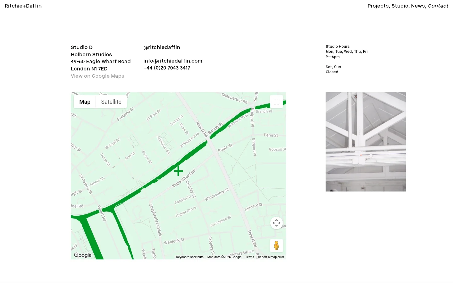 The contact page features a minimalist white layout with black text. It displays the studio address, email, phone number, and Instagram handle in columns above a large Google Map showing the Holborn Studios location. A grayscale architectural photograph of a white ceiling structure is positioned on the right side.
