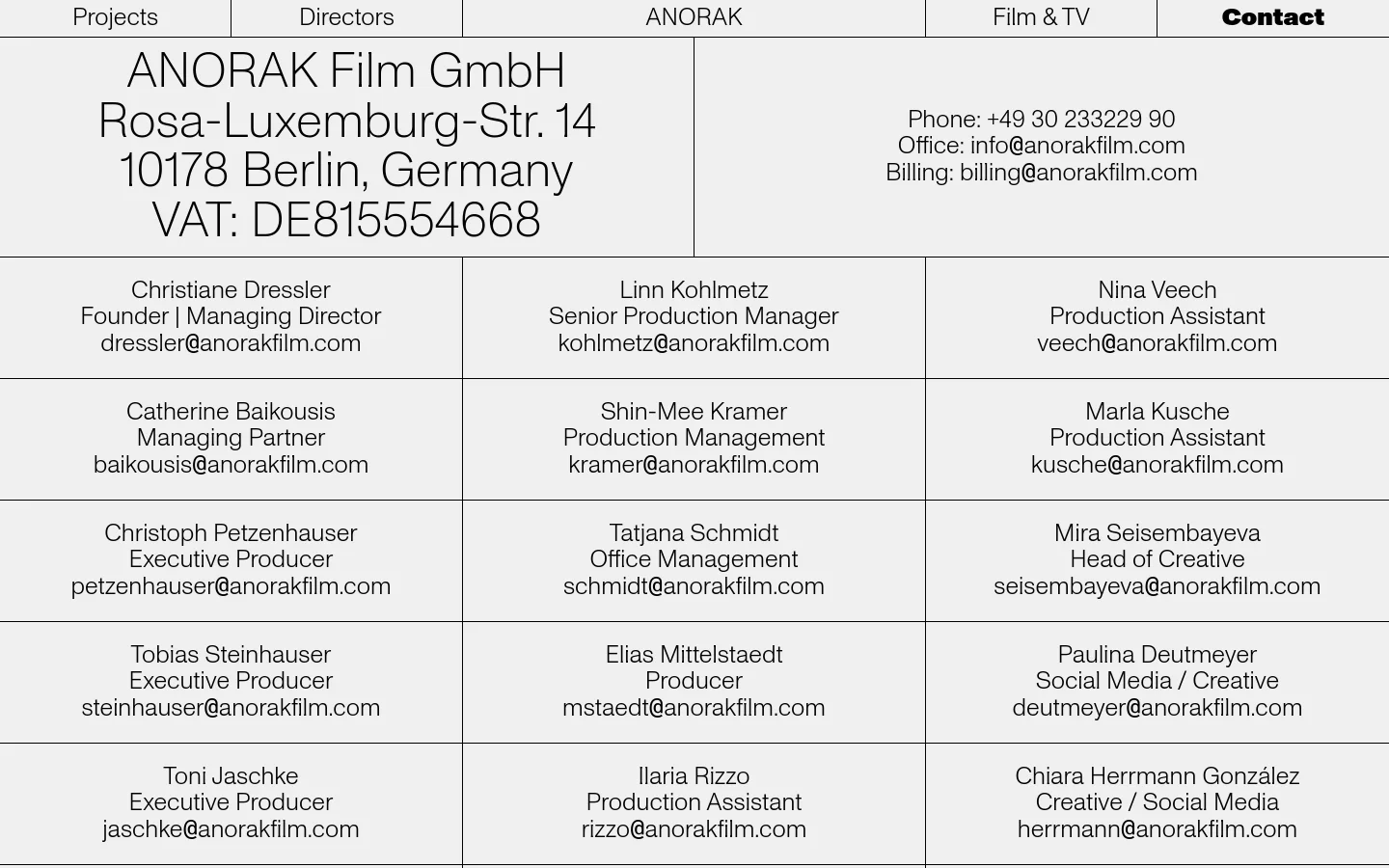 The contact page features a minimalist, grid-based layout with black text on a light grey and white background. The top section displays the company address and contact numbers, followed by a structured grid of names, job titles, and email addresses for the production team. The navigation menu is located at the very top of the page.