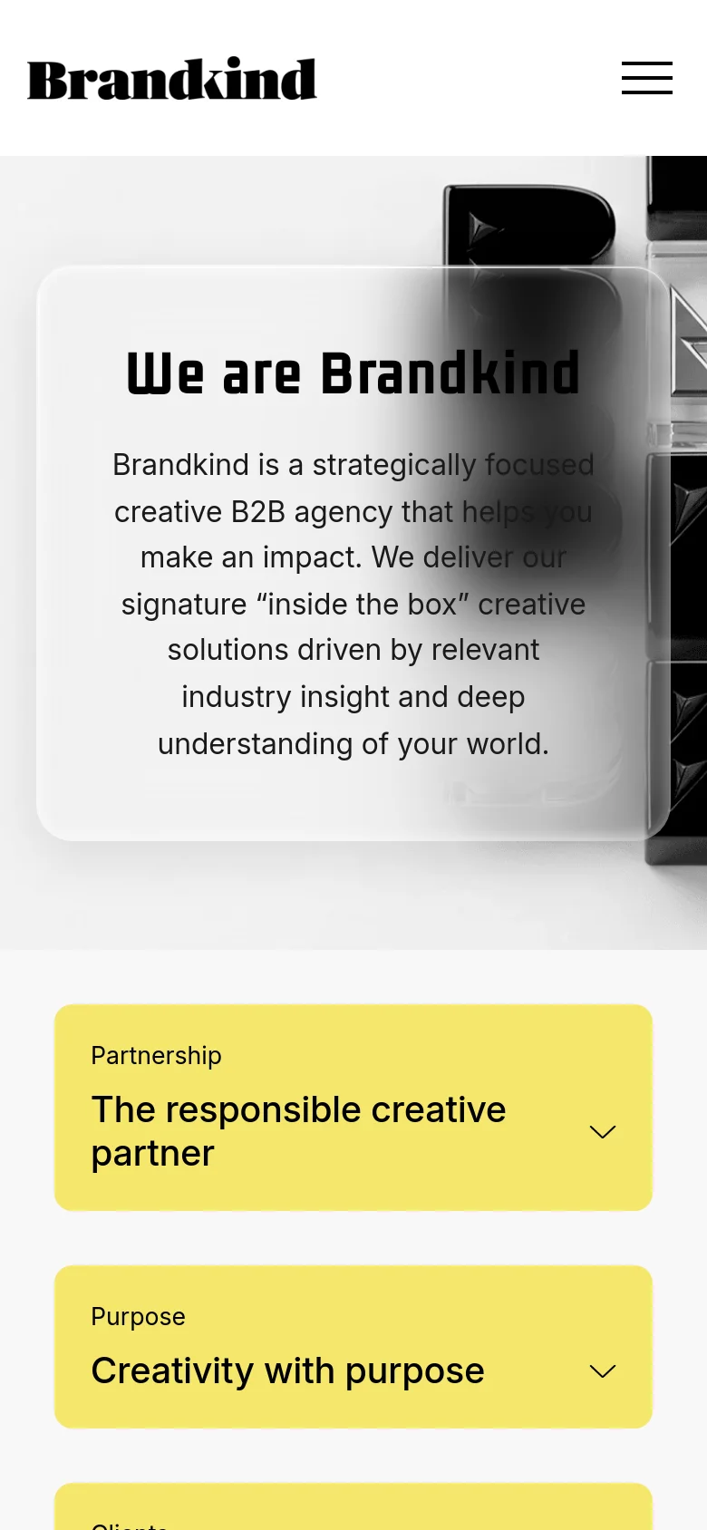The mobile version presents a stacked layout with a centered hero section. The 'We are Brandkind' headline and text are contained within a translucent white overlay box that sits atop the black and white 'B' imagery. The yellow accordion cards for 'Partnership' and 'Purpose' are positioned below, spanning the full width of the screen for easier tapping.