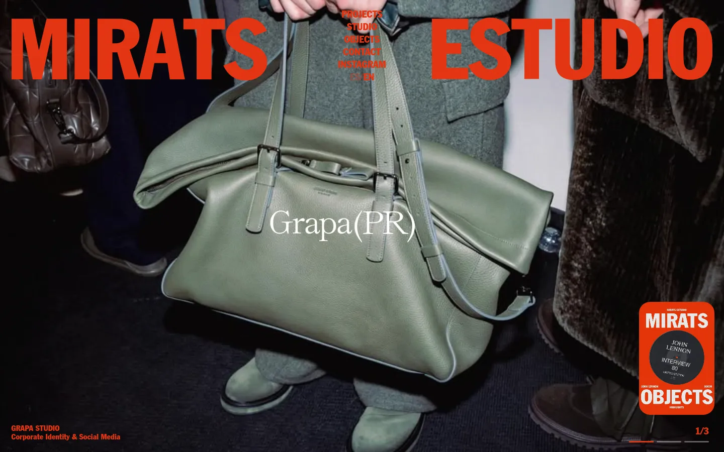 The homepage features a large, full-width hero image of a person holding a sage green leather handbag. Large orange text reading 'MIRATS ESTUDIO' overlays the image, with a smaller navigation menu and the project title 'Grapa(PR)' centered. The bottom left corner displays 'GRAPA STUDIO' in orange text on a dark background.