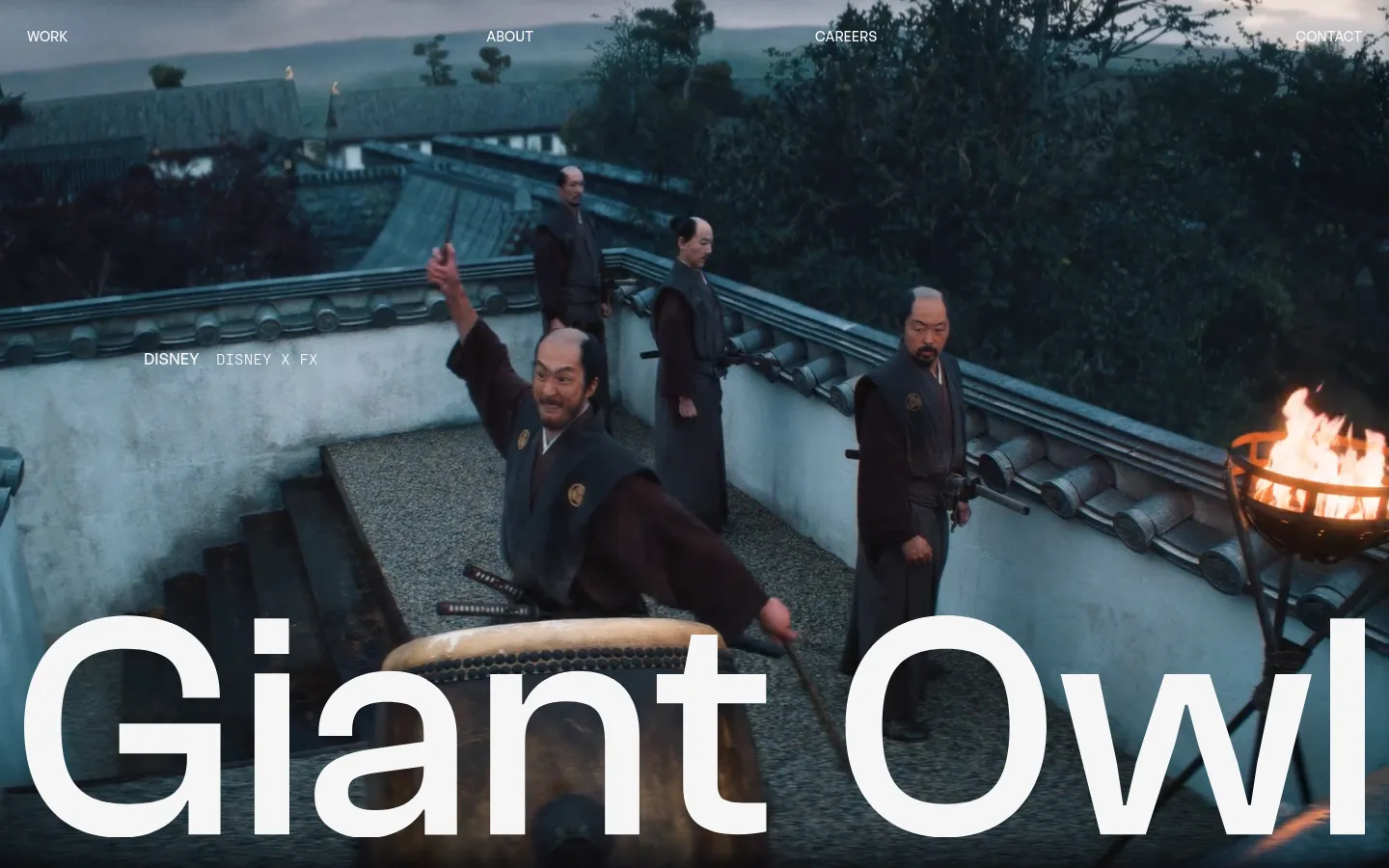 The Giant Owl homepage features a large, cinematic video background showing characters in historical Japanese attire on a rooftop. The brand name 'Giant Owl' is displayed in large white typography at the bottom, with a minimalist navigation menu containing 'WORK', 'ABOUT', 'CAREERS', and 'CONTACT' at the top.